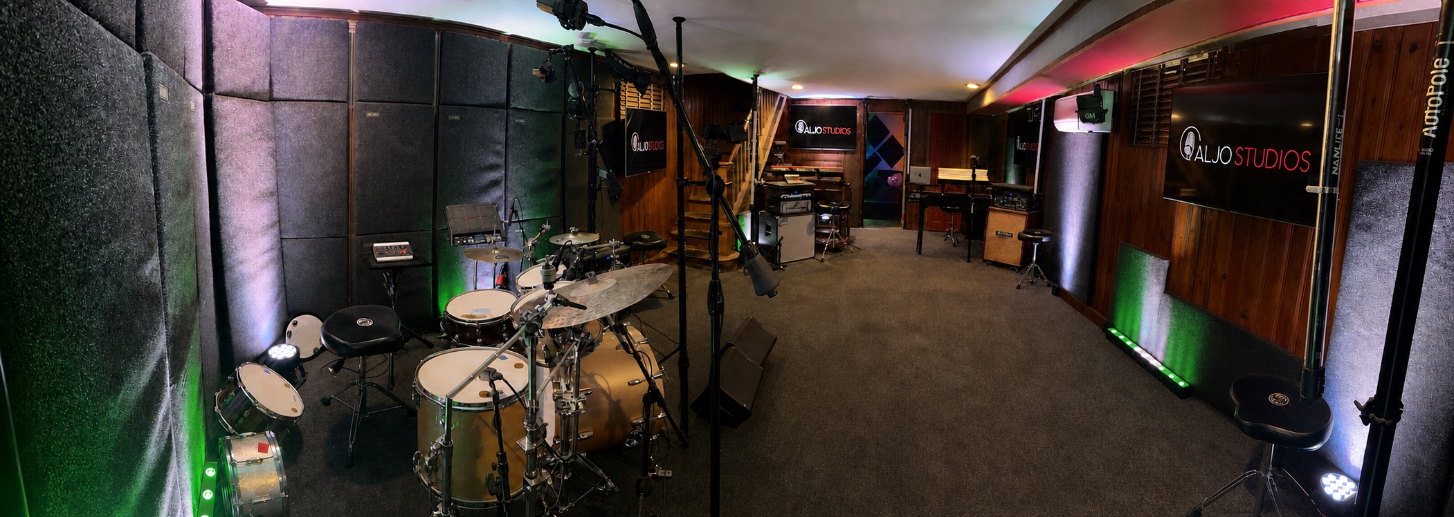 Panoramic view of ALJO Studios with the drum kit, microphones, keyboards, acoustic treatment, and production displays